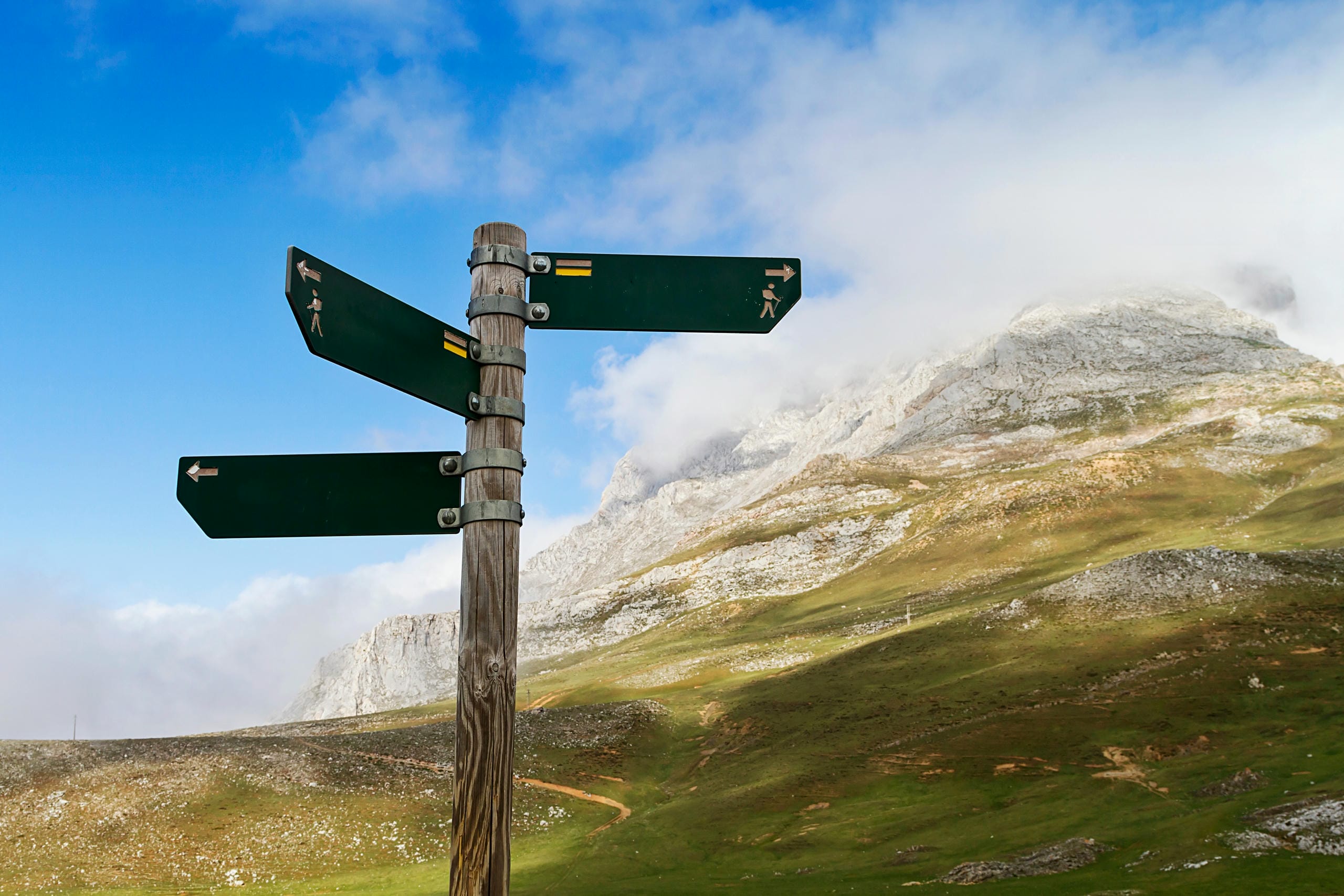 Wegweiser im Gebirge als Symbol für Orientierung durch EU-Regulierungen wie EU-Taxonomie, ESPR, PPWR und DPP, die die Zukunftsfähigkeit von Unternehmen steuern und über Marktfähigkeit, Risiken und Kapitalzugang entscheiden.